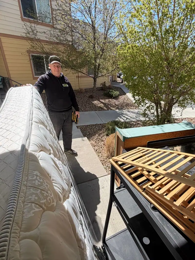Calvin by the truck with a mattress and a wood bed frame ready to load